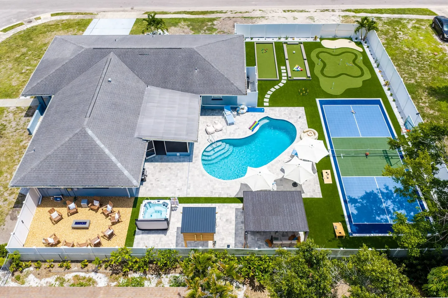 The Breezy Palm: aerial view of the home, pool, sports court and putting green