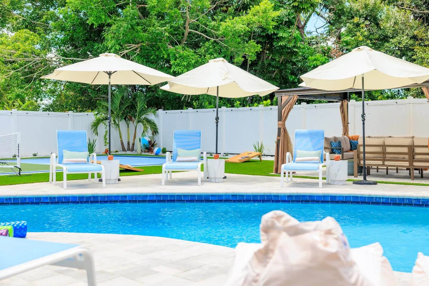 The Breezy Palm: pool with umbrellas and sun loungers