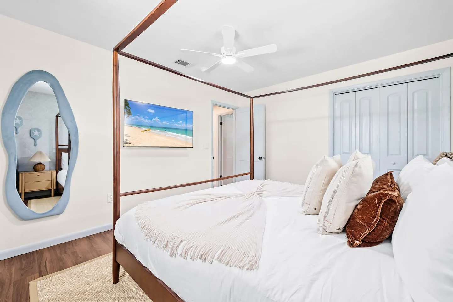 The Breezy Palm: bedroom with canopy bed and ceiling fan