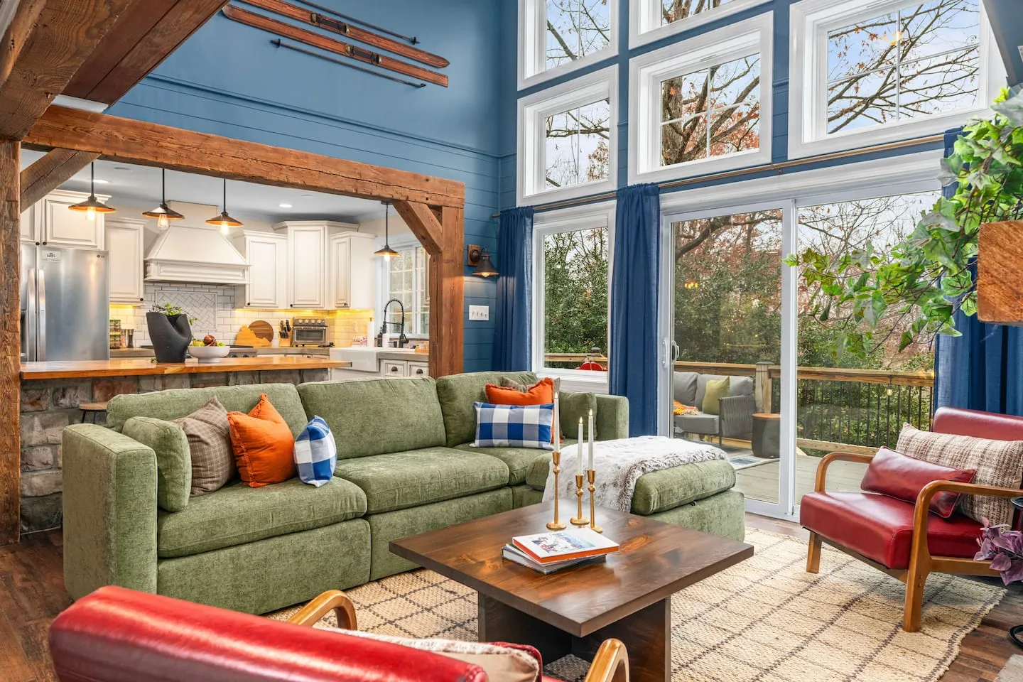 Honey Hollow: living room with green sectional and floor-to-ceiling windows